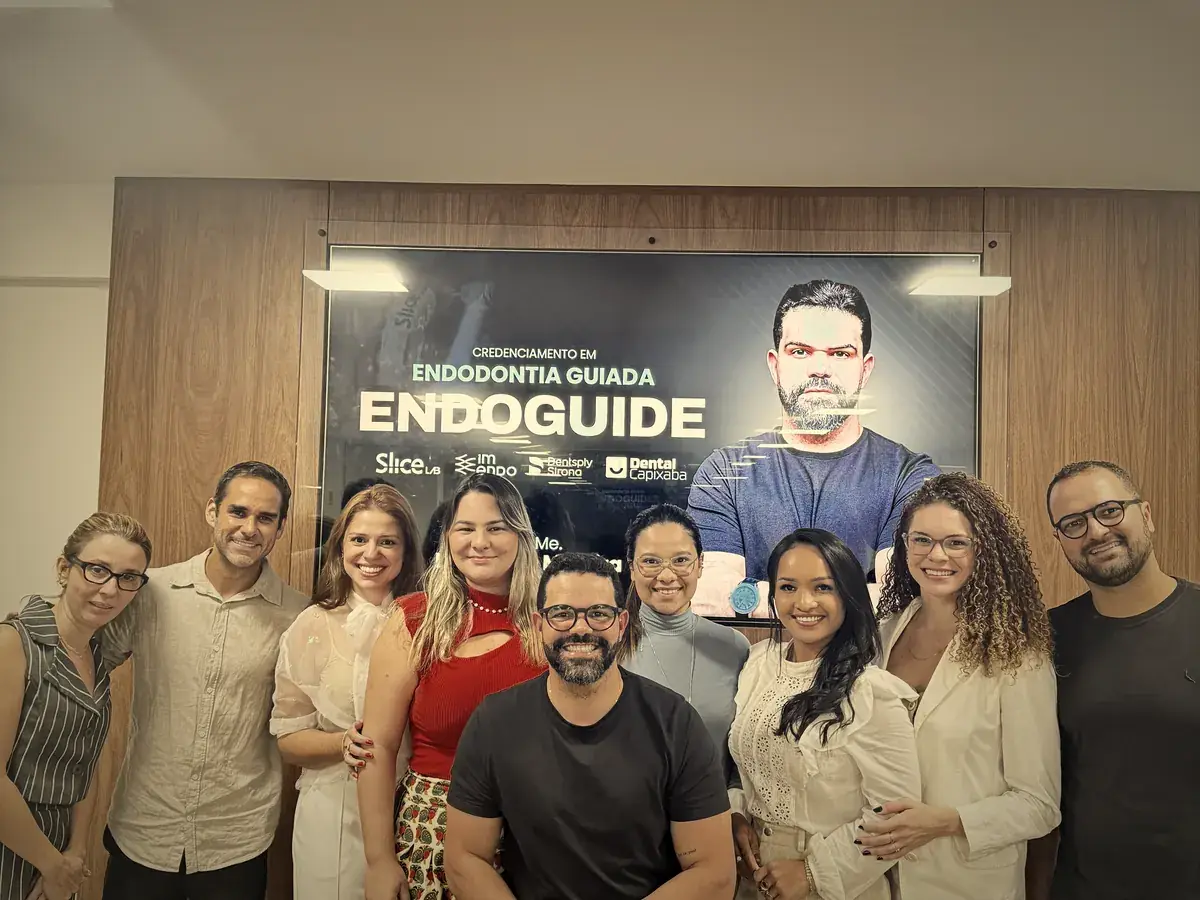 Turma de cirurgiões-dentistas reunida ao lado do painel Endoguide após treinamento em Endodontia Guiada